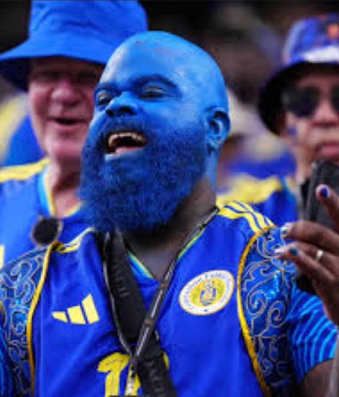 Curacao football supporter painted blue and celebrating in the crowd
